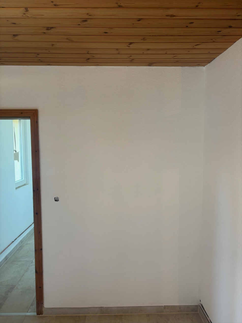 Zimmer nachher: glatt gespachtelte, weiß gestrichene Wände
